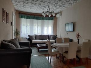 a living room with a couch and a table at Apartman Veiger4 in Siófok +8 photos