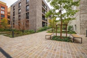 einen Innenhof mit Bänken und einem Baum vor einem Gebäude in der Unterkunft 2 room apartment near PARIS and Metro line 4 in Bagneux