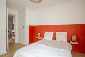 1 Schlafzimmer mit einem weißen Bett mit einem orangefarbenen Kopfteil in der Unterkunft 2 room apartment near PARIS and Metro line 4 in Bagneux