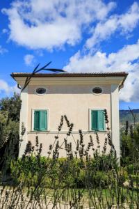 Una casa con persianas verdes a un lado. en Agriturismo Colle Tocci en Subiaco