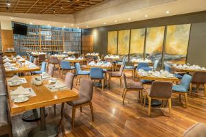 a restaurant with wooden tables and blue chairs at Sheraton Quito in Quito