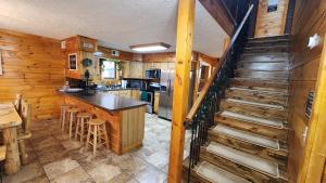 una cocina con paredes de madera y una escalera en una casa en Lazy Bear Cabin, en Sevierville