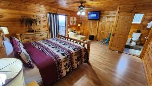 Un dormitorio con una cama en una cabaña de troncos en Lazy Bear Cabin, en Sevierville