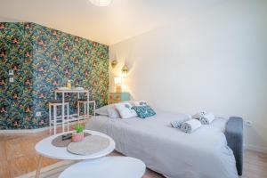 a room with two beds and a table in it at Le Cosy Nest - Studio à Taverny - Ligne H in Taverny