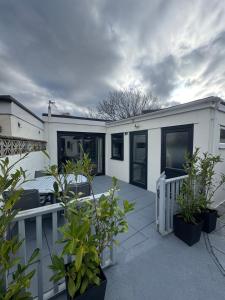 a white house with plants in front of it at Garden Place in Clevedon +17 photos
