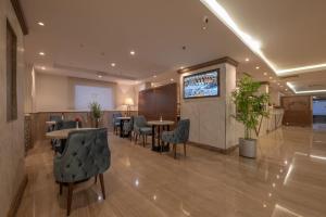 a lobby with tables and chairs and a flat screen tv at Le Beaurivage Hotel in Jeddah