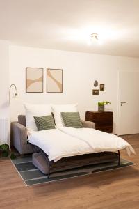 a bedroom with a bed with white sheets and green pillows at FeWo im Herzen von Worpswede in Worpswede