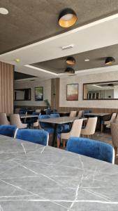 a dining room with blue chairs and tables at Apartman "A" Residence Hill Kopaonik in Kopaonik +50 photos