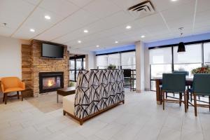 a lobby with a fireplace and a table and chairs at Holiday Inn Express Wilkes Barre East by IHG in Wilkes-Barre