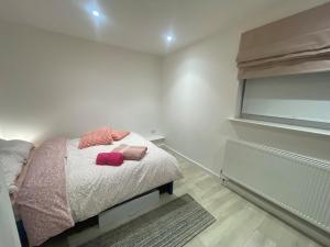 a bedroom with a bed with pink pillows on it at The London Get Away P & M in West Wickham