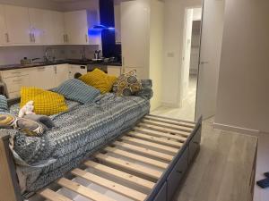 a couch sitting in a living room next to a kitchen at The London Get Away P & M in West Wickham