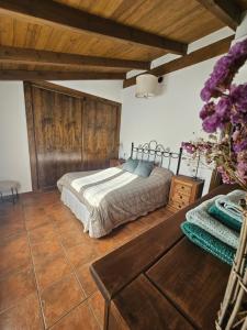 a bedroom with a bed and a wooden wall at El Descanso de Las Hurdes in Sauceda
