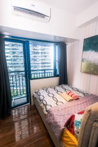 马尼拉Cozy Peacock hideaway Stylish Makati Condo 300 Mbps Gym Swim Park的一间卧室设有一张床和两个大窗户