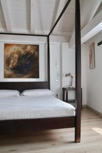 sypialnia z łóżkiem i obrazem na ścianie w obiekcie Bed and Breakfast Casa del Nonno w mieście Adrara San Rocco