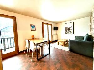 a living room with a table and a couch at La clusaz Centre village , pied des pistes, 42 m2 , balcon sud vue montagne in La Clusaz
