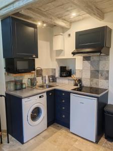 a kitchen with a washing machine and a washer at Gite a collonges la rouge avec spa in Collonges +20 photos
