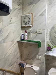 a bathroom with a toilet and a fan on the wall at Tiba Golden Resort in Hurghada