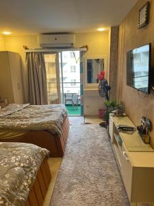 a hotel room with two beds and a television at Tiba Golden Resort in Hurghada