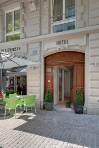 um hotel com mesas e cadeiras em frente a um edifício em Hotel Platzhirsch em Zurique