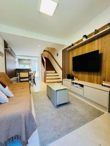 ein Schlafzimmer mit einem Bett, einem Fernseher und einem Tisch in der Unterkunft MRG - Convidativa Casa 3D em Condomínio Privativo em Canela - Próximo ao Parque Terra Mágica Florybal in Canela