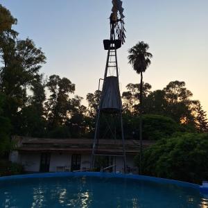 a windmill sitting on top of a house with a pool at Chacra del Molino in Navarro