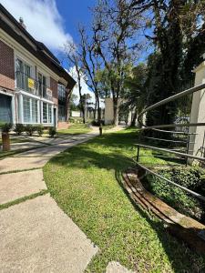 einen Gang vor einem Gebäude mit einem Baum in der Unterkunft MRG - Convidativa Casa 3D em Condomínio Privativo em Canela - Próximo ao Parque Terra Mágica Florybal in Canela