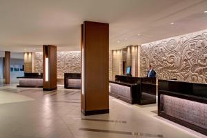 a lobby of a hotel with a man in a suit at Houston Airport Marriott at George Bush Intercontinental in Houston