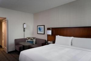 a hotel room with a large bed and a chair at Houston Airport Marriott at George Bush Intercontinental in Houston +33 photos