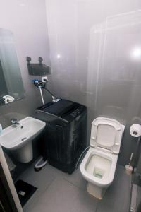 马尼拉Cozy Peacock hideaway Stylish Makati Condo 300 Mbps Gym Swim Park的浴室里有白色马桶和洗手池