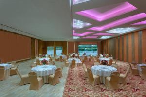 a banquet hall with white tables and chairs and purple ceilings at Courtyard by Marriott Madurai in Madurai