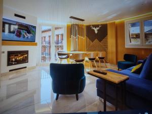 a living room with a blue couch and a table at BALCON DE BENASQUE Losa Radiante Cama King Alta Gama Parking Opcional in Benasque