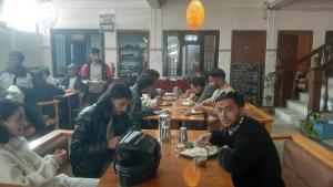 un gruppo di persone seduti a un tavolo in un ristorante di Hotel Lake n Yeti a Pokhara Altre 7 foto