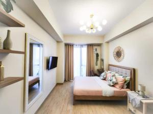 a bedroom with a bed and a television in a room at Bangs Hive at Palladium Megaworld in Iloilo City
