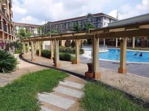 a pavilion with a swimming pool in a building at Cozy 1 Bedroom Unit Arezzo Place Pasig in Pasig