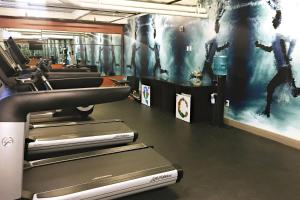 a gym with cardio machines and a wall with a picture at Q&C Hotel and Bar New Orleans, Autograph Collection in New Orleans