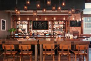 a bar with a large wooden table and chairs at Q&C Hotel and Bar New Orleans, Autograph Collection in New Orleans