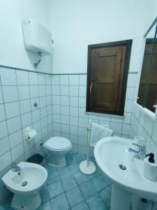ein Badezimmer mit zwei Waschbecken und einer Toilette in der Unterkunft Acchianata Santo Spirito in Agrigento + 19 Fotos