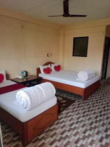 a hotel room with two beds and a flat screen tv at Sauraha Inn in Sauraha