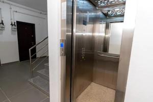 a metal elevator in a room with stairs at By the Sea Plusoi Apartment in Năvodari