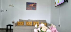 a living room with a couch and a tv at By the Sea Plusoi Apartment in Năvodari