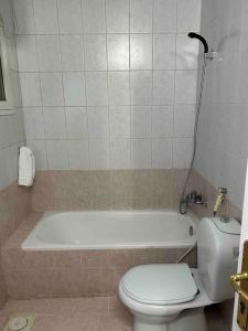 a bathroom with a toilet and a bath tub at عمارة المحيسني in Makkah