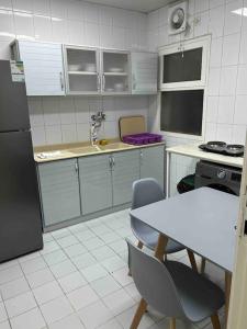 a kitchen with a refrigerator and a table and chairs at عمارة المحيسني in Makkah +24 photos