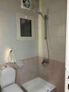 a small bathroom with a toilet and a shower at عمارة المحيسني in Makkah