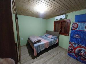 a small bedroom with a bed in a room at Casa familiar mozzaquatro in São Gabriel