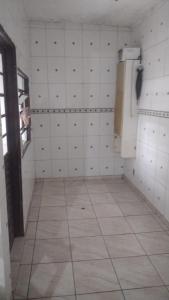 a bathroom with a toilet and a phone on the wall at Casa Branca Sobrado in Caraguatatuba
