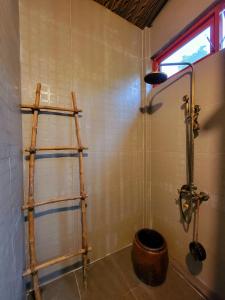 a bathroom with a shower and a wooden shelf at Nông Trại Thảnh Thơi in Ben Tre