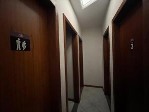 a hallway with two doors and a sign on the wall at Angel Hospedagem Itapuã in Vila Velha