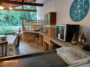 a kitchen with a table and a counter with a microwave at Charmosa edícula próxima a praia in São Sebastião