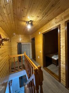 a wooden room with a staircase and a bed in it at Cabana Violeta Arieseni in Arieşeni