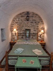 ein Schlafzimmer mit einem Bett in einer Steinwand in der Unterkunft Vathia view in Vathia